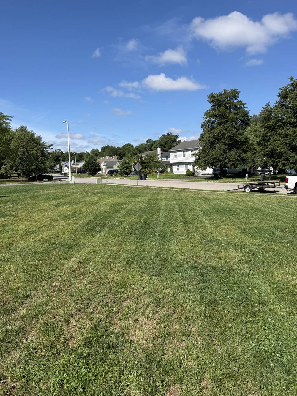 Striped freshly mowed front lawn on a sunny day